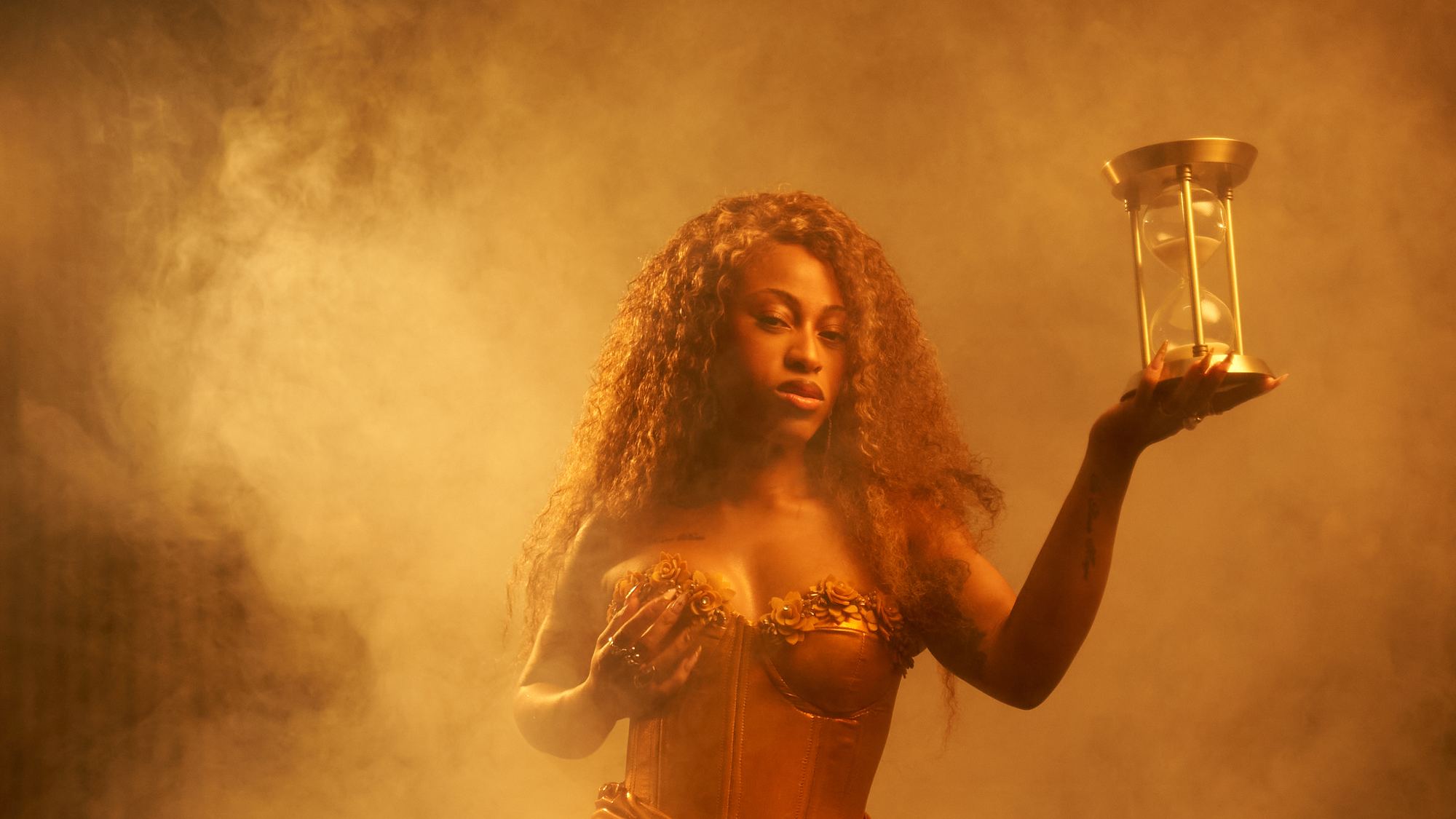 Princess Wonda holding a golden hourglass in a room full of smoke.